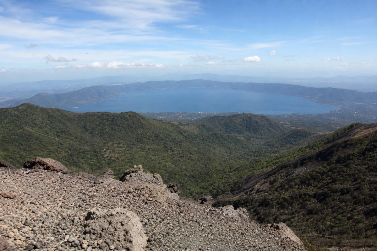 View from the summit rim of Santa Ana volcano over rolling green ridges to the wide blue caldera of Lake Coatepeque in the distance