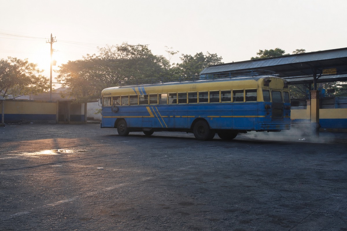 Old painted city bus idling at a Santa Ana terminal in soft early light before the morning run to the volcano