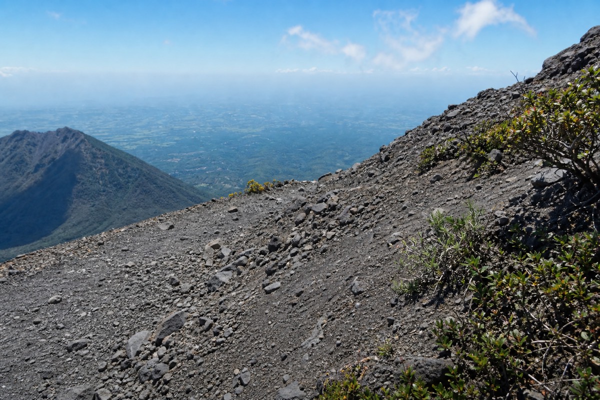 Loose grey volcanic rock on the upper Santa Ana trail under strong midday sun