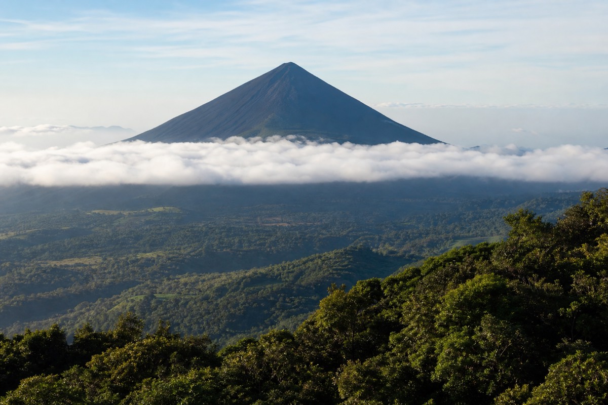 The black cone of Izalco volcano seen from the upper Santa Ana trail with cloud below it