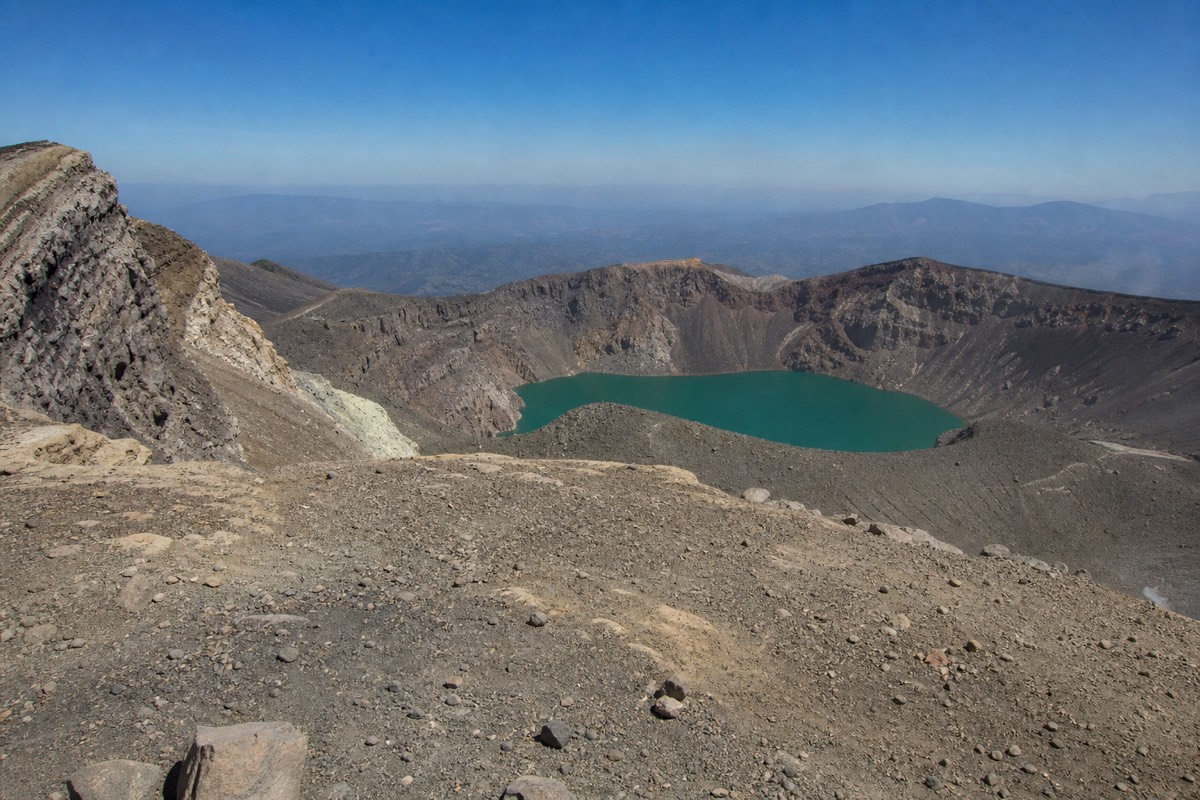 Late-morning light on the summit rim of Santa Ana volcano with the turquoise crater lake below and clear sky above