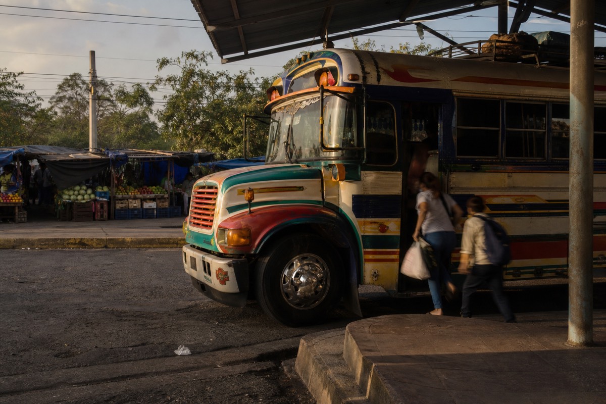 Old painted bus waiting at a terminal in Santa Ana city in early morning light before the run to the volcano trailhead