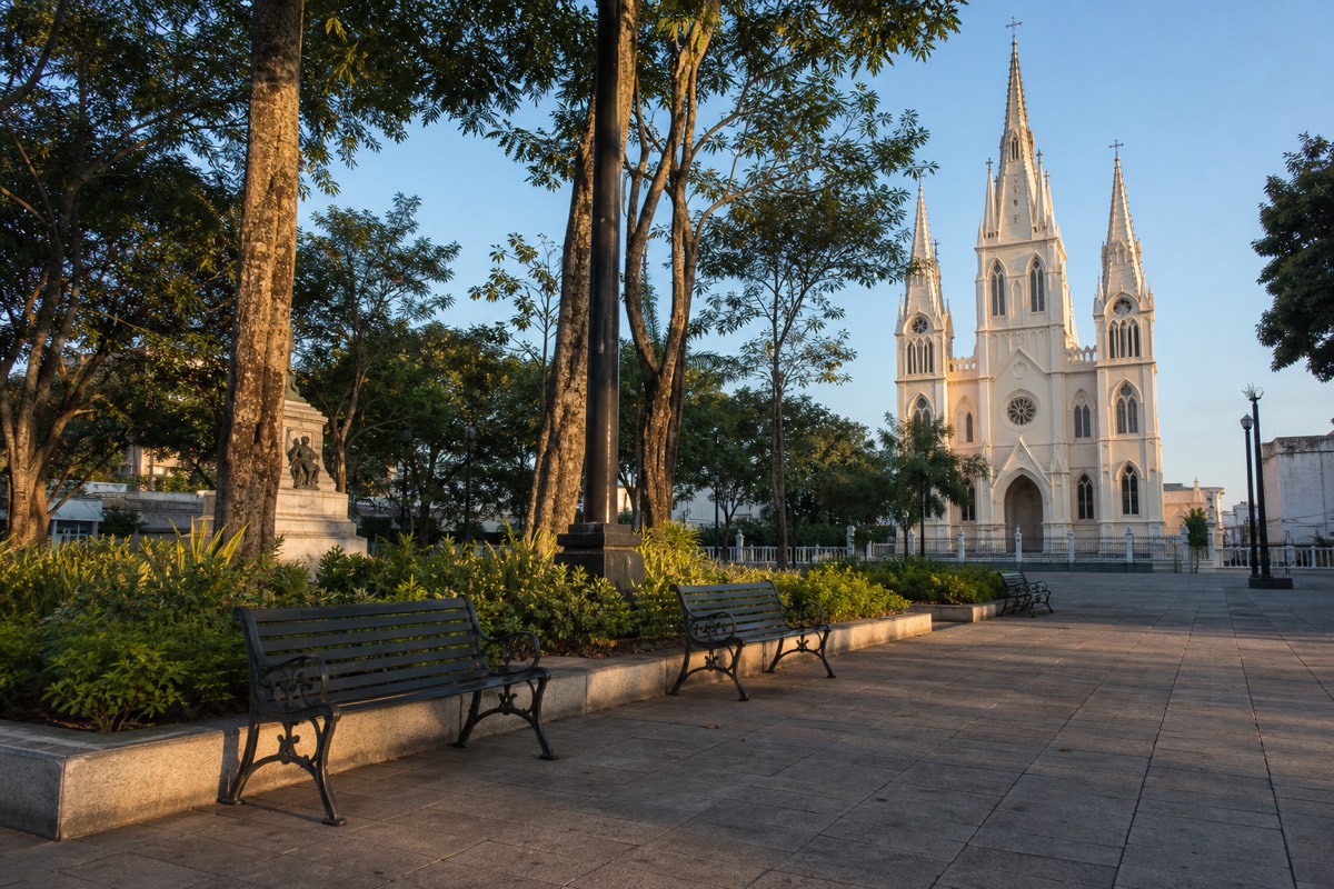Early morning on Santa Ana's central square with the cathedral spires catching first light and empty benches
