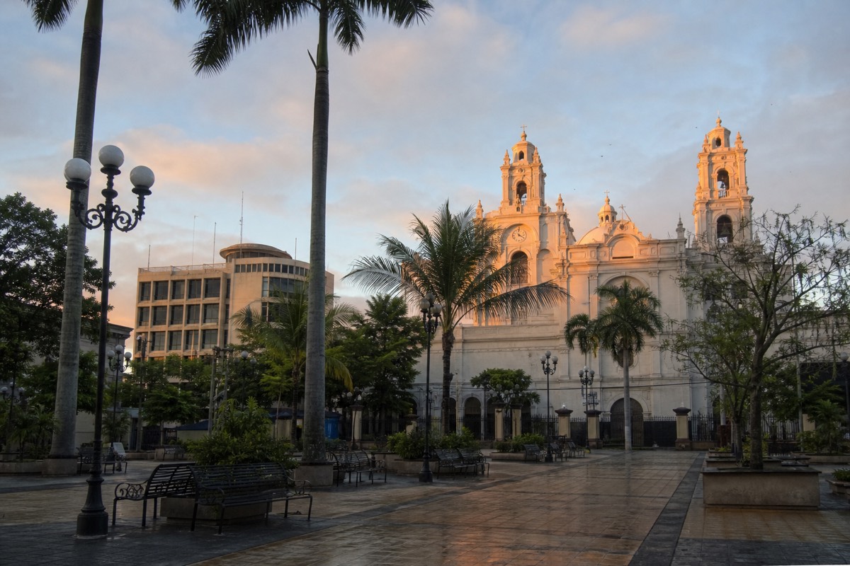 Central plaza of Santa Ana, El Salvador, at dawn with the cathedral's pale spires catching first light